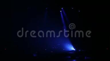蓝色聚光灯在黑暗中的一个空音乐会舞台上。 舞台灯光。